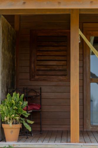 a porch of a house with a chair and a plant at Villa Mango in Icaraí