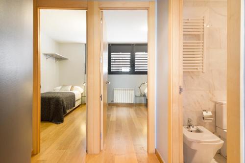 巴塞隆納的住宿－Barcino Inversions - Bright Apartment in Gracia with shared Pool，一间带卫生间的浴室和一间带一张床的卧室
