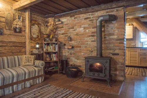 a living room with a brick wall with a stove at Gervių giesmė - country homestead in Viliūšiai