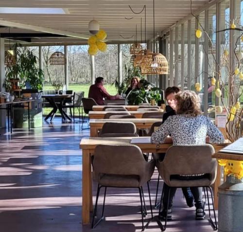 a group of people sitting at tables in a restaurant at Landhotel Diever in Diever