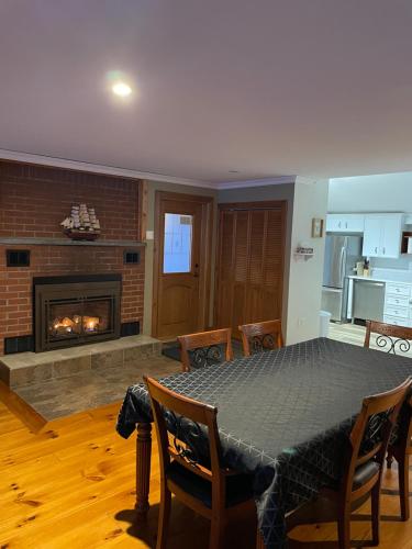 a living room with a table and a fireplace at L'Oasis in Ascot Corner