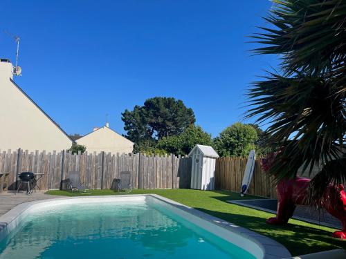 - une piscine dans un jardin avec une clôture en bois dans l'établissement Chez Arnold - Maison à moins dun km de la plage, à La Turballe