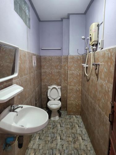 ein Bad mit einem WC und einem Waschbecken in der Unterkunft Vang Vieng Chanthala Hotel 1 in Vang Vieng