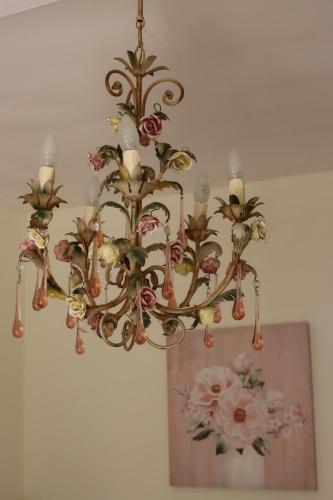 a chandelier hanging from a ceiling with flowers on it at Appartamento Timo in Acquedolci