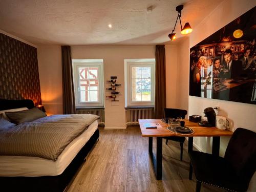 a bedroom with a bed and a desk and a table at Pension Winnemuller in Cochem