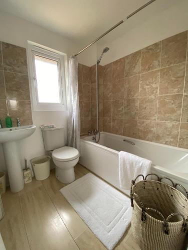 ein Badezimmer mit einer Badewanne, einem WC und einem Waschbecken in der Unterkunft ROSE COTTAGE in Ryde