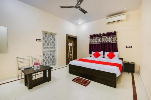 a bedroom with a bed and a table and a window at OYO Flagship Hotel Rudraksh Inn in Rānchī