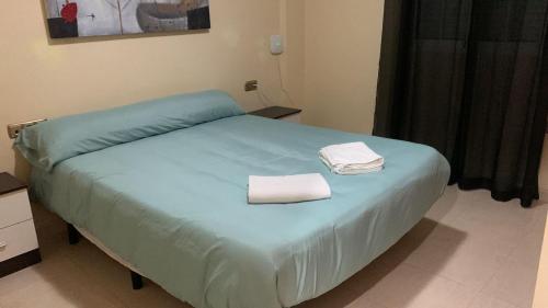 Una cama en una habitación con dos toallas. en APARTAMENTO ZENIA PLAYA GOLF II en Alicante