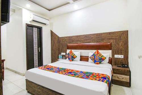 a bedroom with a large white bed with colorful pillows at FabHotel La Vista in Zirakpur
