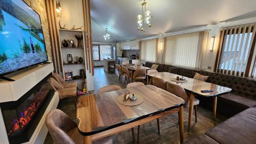 a restaurant with tables and chairs and a fireplace at ЕЛЕГАНС къща за гости in Dospat