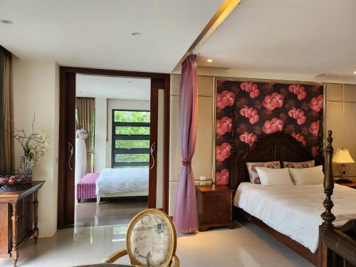 1 dormitorio con 1 cama grande y pared de flores en Zhe Juan Meng Tian, en Sanyi