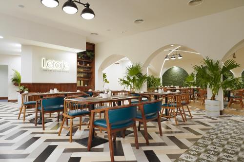 ein Restaurant mit Holztischen und blauen Stühlen in der Unterkunft Blue Beach Tower The Walk JBR in Dubai