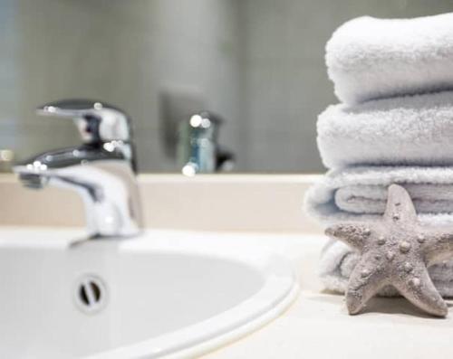 La salle de bains est pourvue d'un lavabo, de serviettes et d'une étoile de mer. dans l'établissement Hotel Seestern, à Röbel