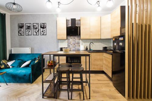 a kitchen with a table and a blue couch at Apartament Tatarska Przemyśl in Przemyśl