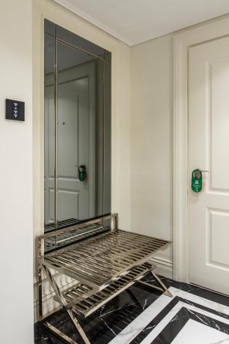 a bed in a room with a mirror on the wall at Xheko Imperial Luxury Hotel & SPA in Tirana