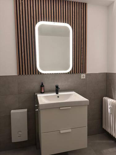 bagno con lavandino bianco e specchio di Ferienwohnung Sonitschka a Lörrach