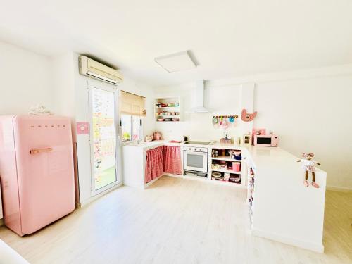 uma cozinha com electrodomésticos cor-de-rosa e um frigorífico cor-de-rosa em Mi casa es la tuya em Caudiel