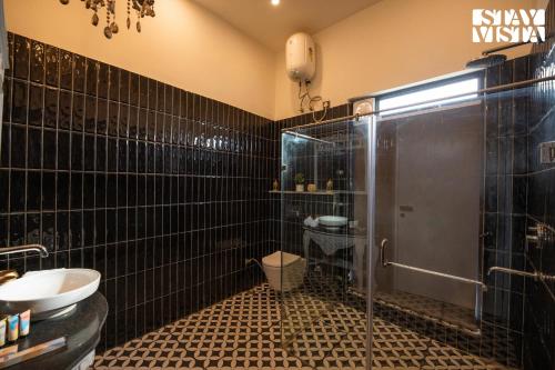 a bathroom with a shower and a toilet and a sink at StayVista's The Sweet Life - 5BHK Farm-View Pet-Friendly Villa with Outdoor Pool in Sohna
