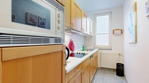 a kitchen with a sink and a microwave at Ferienwohnung a cappella 68 im Ostseebad Binz, ID 668 in Binz