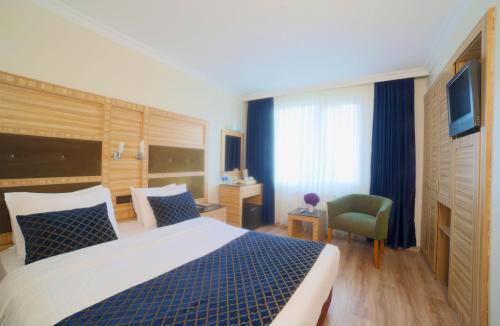 a hotel room with a large bed and a chair at Sed Bosphorus Hotel in Istanbul