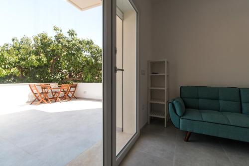 a living room with a green couch and a window at Appartamento Perla Bianca, con WiFi e Air Con in Cala Gonone