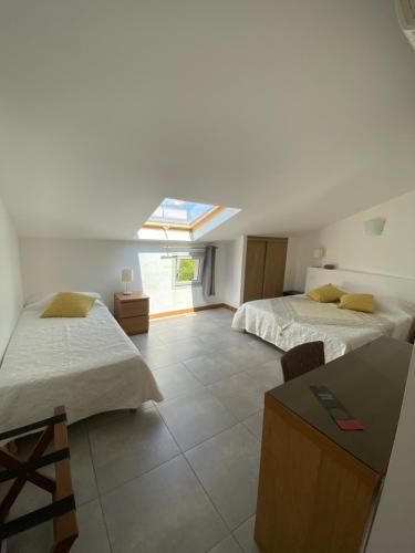 Großes Zimmer mit 2 Betten und einem Fenster in der Unterkunft Hôtel Restaurant Petra Cinta in Barcaggio