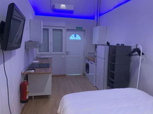 um quarto com uma cama, uma televisão e uma cozinha em At 20' by Metro from the city centre (A) em Madri