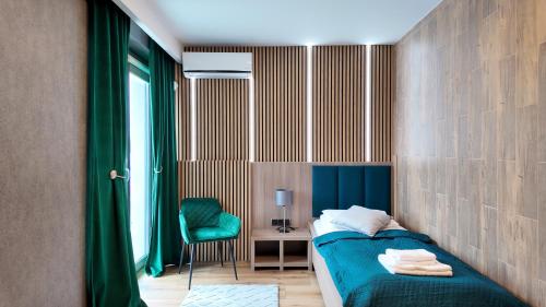 a small bedroom with a bed and a chair at Hotel Oskar Business & Spa in Puławy