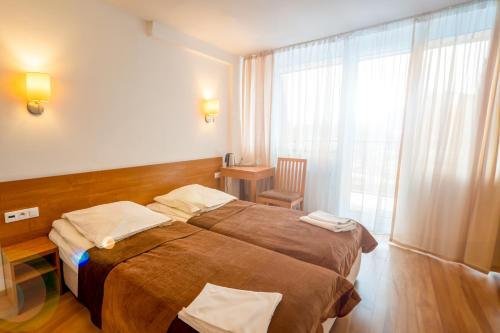 a hotel room with a large bed and a window at Sanatorium Budowlani Szczawnica in Szczawnica