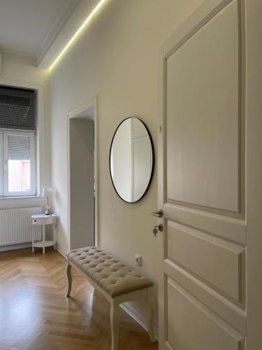 a room with a door and a stool and a mirror at Mama Apartmani in Smederevo
