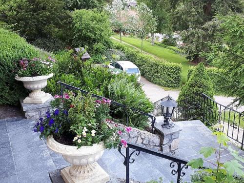 a garden with two large vases filled with flowers at Haus Kurparkblick in Todtmoos