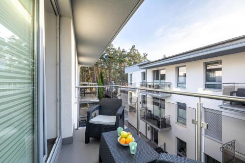 a balcony with chairs and a table with fruit on it at Seaside Apartment with Balcony in Pobierowo - Close to Beach by Renters in Pobierowo