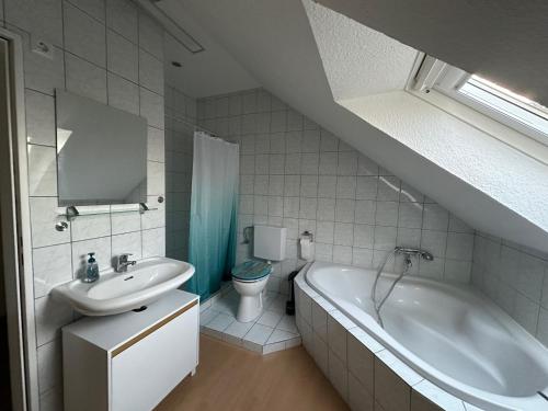 een badkamer met een wastafel, een bad en een toilet bij Wolburg am Grossensee in Großensee