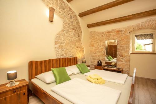 Schlafzimmer mit einem Bett mit grünen und weißen Kissen in der Unterkunft Villa Milka in Labin