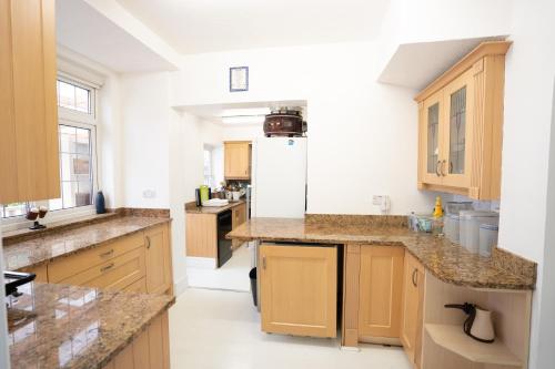 a kitchen with wooden cabinets and granite counter tops at House with Garden & BBQ in Edmonton