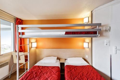two beds in a room with two bunk beds at Premiere Classe Besancon Ecole Valentin in Besançon