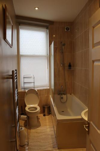 uma casa de banho com um WC, uma banheira e um lavatório. em Modern 2 Bedroom Apartment Notting Hill Gate/Kensington em Londres