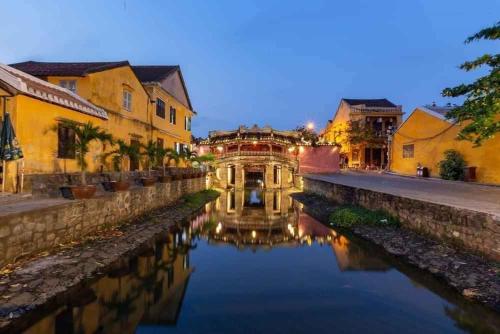un canal au milieu d'une ville la nuit dans l'établissement Bana Home & Spa, à Hội An
