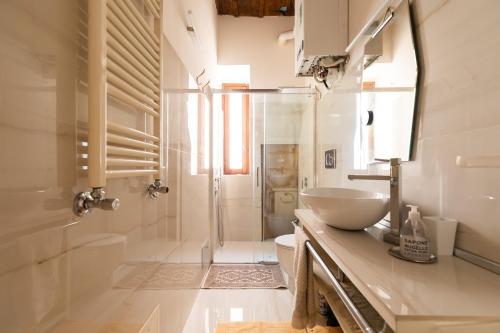 a white bathroom with a sink and a shower at Reginella White Apartment in Rome