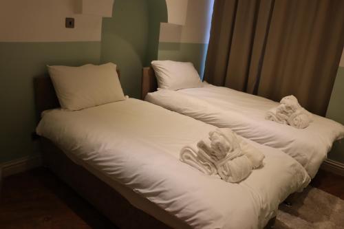 duas camas com toalhas num quarto em Modern 2 Bedroom Apartment Notting Hill Gate/Kensington em Londres