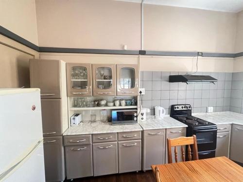 a kitchen with stainless steel appliances and a table at tripple s guest house in Cape Town