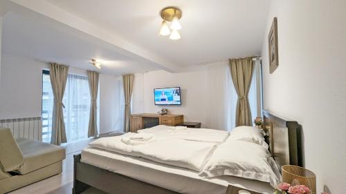 1 dormitorio con 1 cama, TV y silla en Complex Parc Pini Moinesti en Moineşti