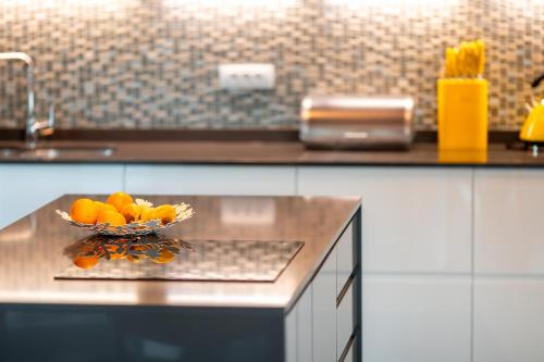 a bowl of oranges on a counter in a kitchen at Korcula Luxury Apartments in Korčula