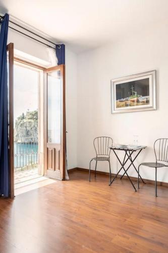 a living room with a table and chairs and a window at Isola Bella - Rooms il Pescatore in Taormina