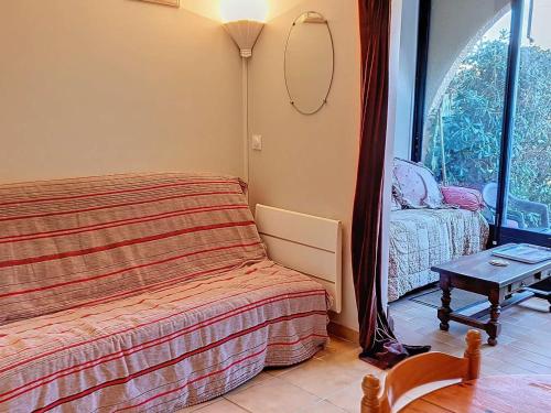 Schlafzimmer mit einem Bett, einem Tisch und einem Fenster in der Unterkunft Appartement Bormes-les-Mimosas, 2 pièces, 4 personnes - FR-1-610-97 in Bormes-les-Mimosas