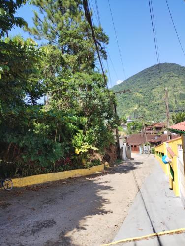 eine Straße in einer Stadt mit einem Berg im Hintergrund in der Unterkunft Casa praia da enseada em Ubatuba in Ubatuba