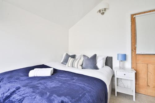 een slaapkamer met een groot bed en een blauwe deken bij StayRight Homely 3 Bedroom House in Vibrant Whitchurch in Cardiff