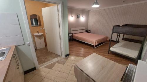 a small room with a bedroom and a bunk bed at Plieņciems Urgas in Plieņciems