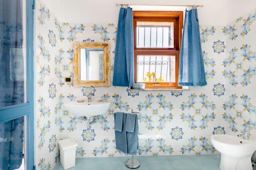 a bathroom with blue and white flowers on the wall at Isola Bella - Rooms il Pescatore in Taormina