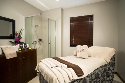a bathroom with a bed with a shower and a sink at Fiesta Residences Boutique Hotel and Serviced Apartments. in Accra